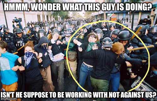 HMMM, WONDER WHAT THIS GUY IS DOING? ISN'T HE SUPPOSE TO BE WORKING WITH NOT AGAINST US? | image tagged in agent provocateur,mole,sabotage,protesters,plant,police | made w/ Imgflip meme maker
