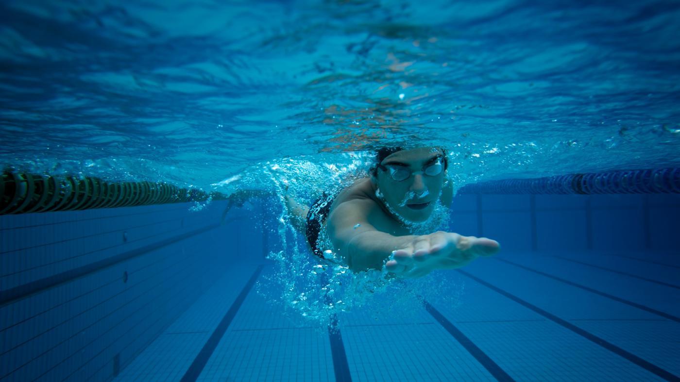 Парень купается в бассейне. Плавание. Плавание в бассейне. Бассейн под водой. Человек плывет в бассейне.