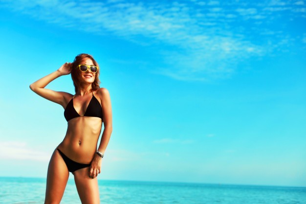 Smiling woman on beach in bikini Blank Meme Template