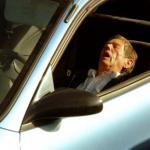 old man sleeping in car