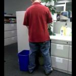 Man pissing on office plant