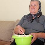 Elderly woman eating popcorn