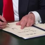 trump signing middle finger