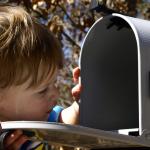 kid looking in mailbox