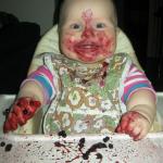 Excited baby with dessert on face