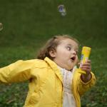Little girl running in yellow jacket