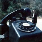 Man with huge dial telephone