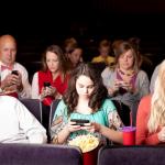 People on their phones at a movie