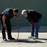 two men looking down into a sewer