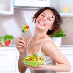 Woman laughing eating a salad