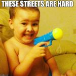 Baby with gun | THESE STREETS ARE HARD | image tagged in baby with gun | made w/ Imgflip meme maker