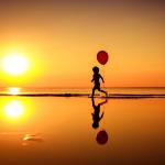 Child Silhouette On Beach With Balloon