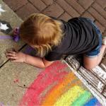 child painting sidewalk rainbow