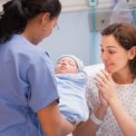 Nurse handing over newborn baby