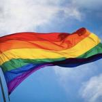 Gay pride flag waving, against sky