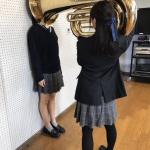 Girl Putting Tuba On Girl's Head