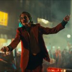 Joker standing on cop car during riot, in Joker 2019 (Batman)