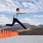 Man Leaps Over Row Of Obstacle Pilons In Desert Playa