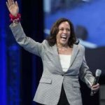 Kamala harris with one hand up