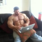 Buff guy typing on a laptop