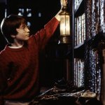 Harry Potter holding lantern up to bookshelf