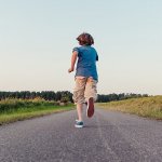 Boy running away road