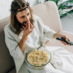 Jesus eating popcorn and watching tv