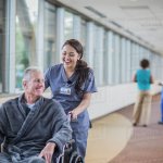 Nurse pushing old man wheelchair