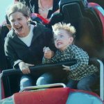 kid with mother on roller coaster