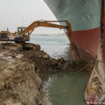 Excavator digging out Evergreen ship in Suez canal