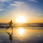 Running in front of a sunset at the beach