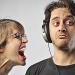 Woman screaming at man wearing headphones