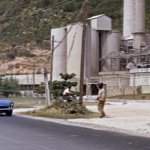 Bond driving past factory.