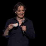 DYLAN MORAN STANDUP with microphone and teacup