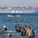 People swimming with container ship in background meme