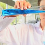 Scientist Pouring Liquid Into Beaker