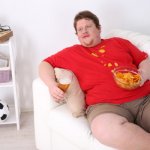 fat man on couch eating chips