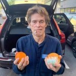 Willem Dafoe holding two oranges