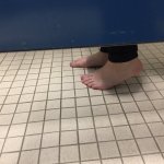Feet under bathroom stall