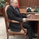 Putin clutching onto the table