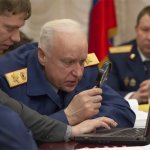 Russian general looking at laptop with magnifying glass