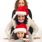 three people with santa hats laying on top of each other