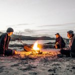 Three guys around fire