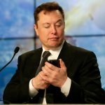 Elon Musk checks his phone