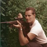 Charlton Heston firing a rifle