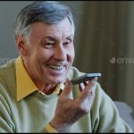 Old man using speaker phone
