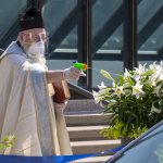 Priest spraying holy water doing safe distance