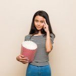Young Woman with a bucket of popcorn.