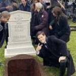 man doing peace sign at grave