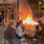 French couple dining behind riots